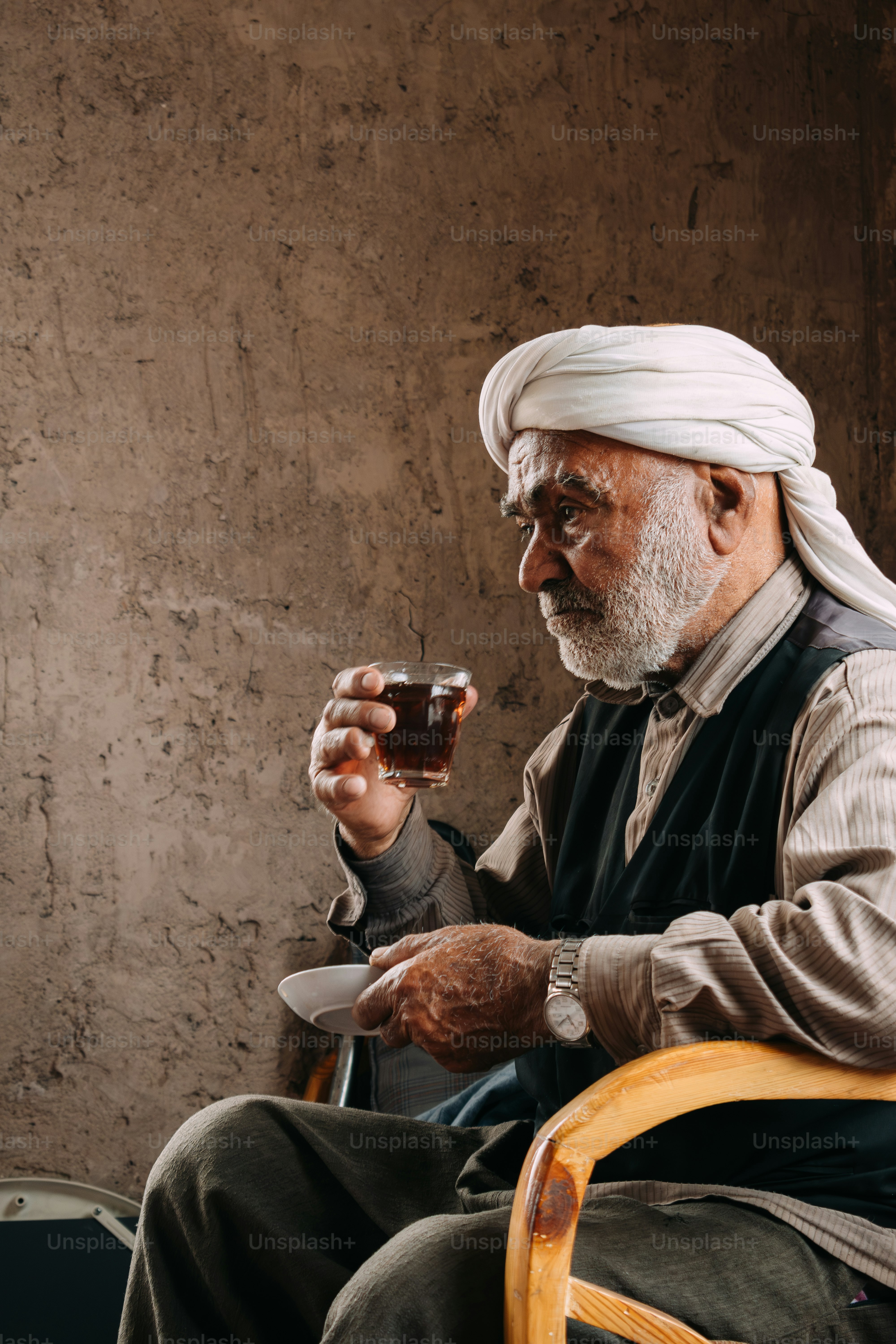 a man sitting in a chair holding a glass of wine