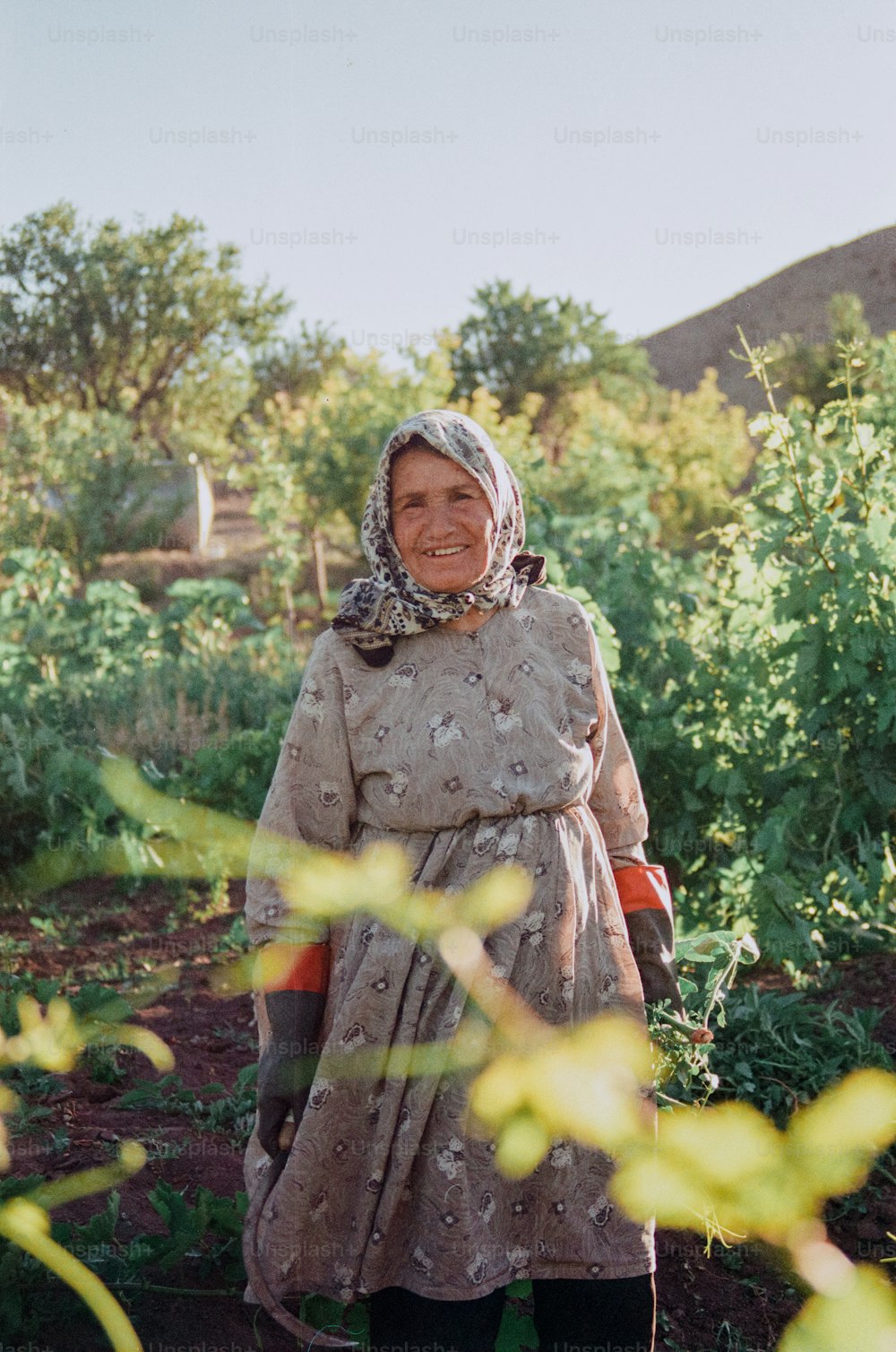 Una donna in piedi in un campo con un sorriso sul suo volto