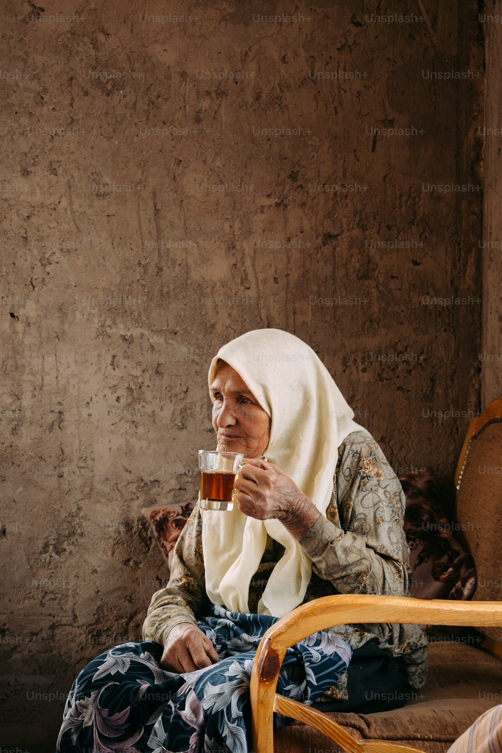 a woman sitting on a chair holding a glass of beer
