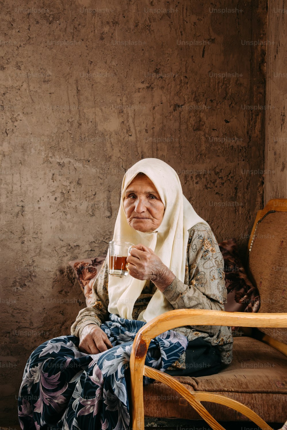 Une femme assise sur une chaise tenant un verre de vin