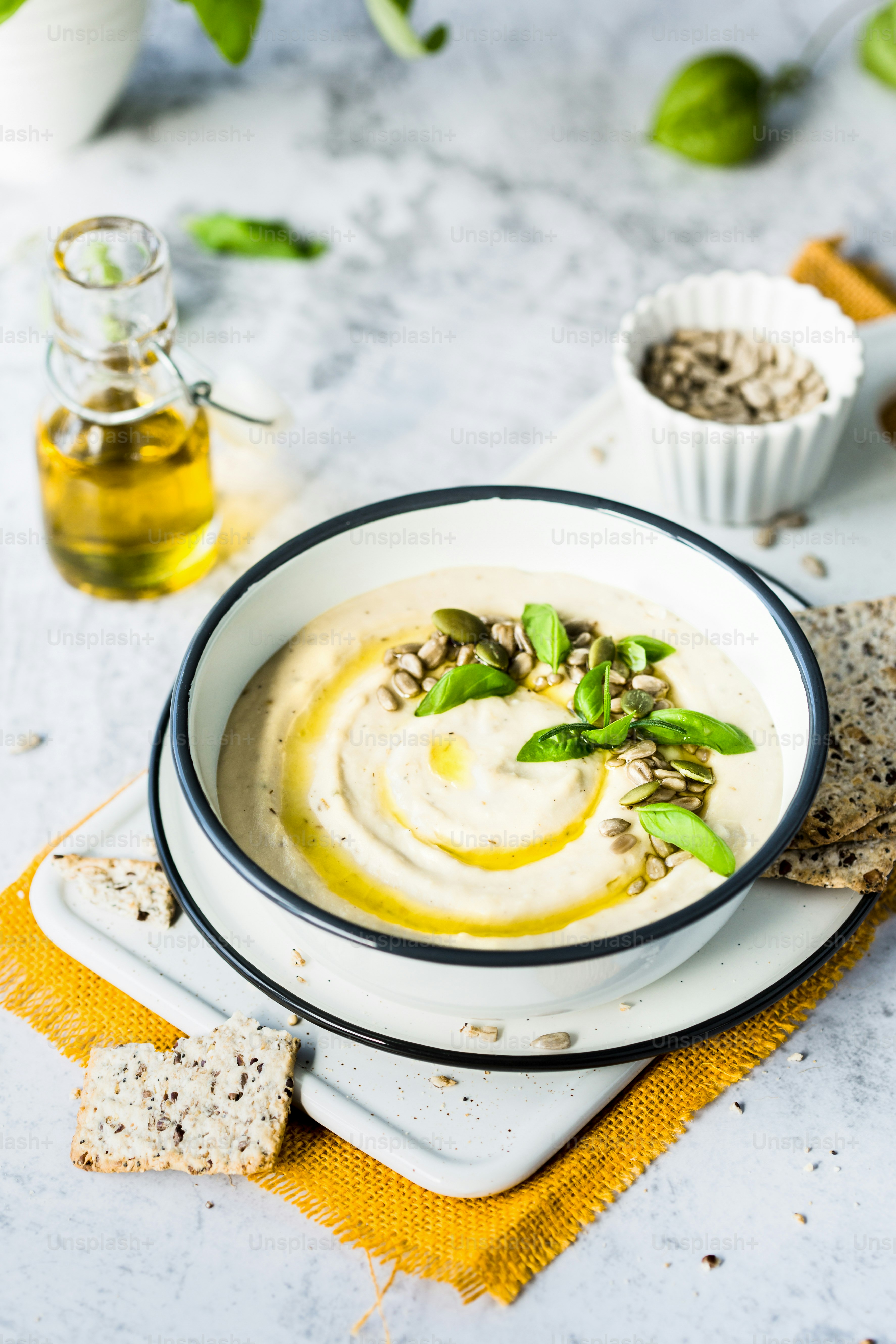 uma tigela de homus está sentada em um prato