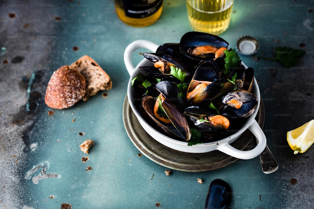 a bowl of mussels and a glass of wine