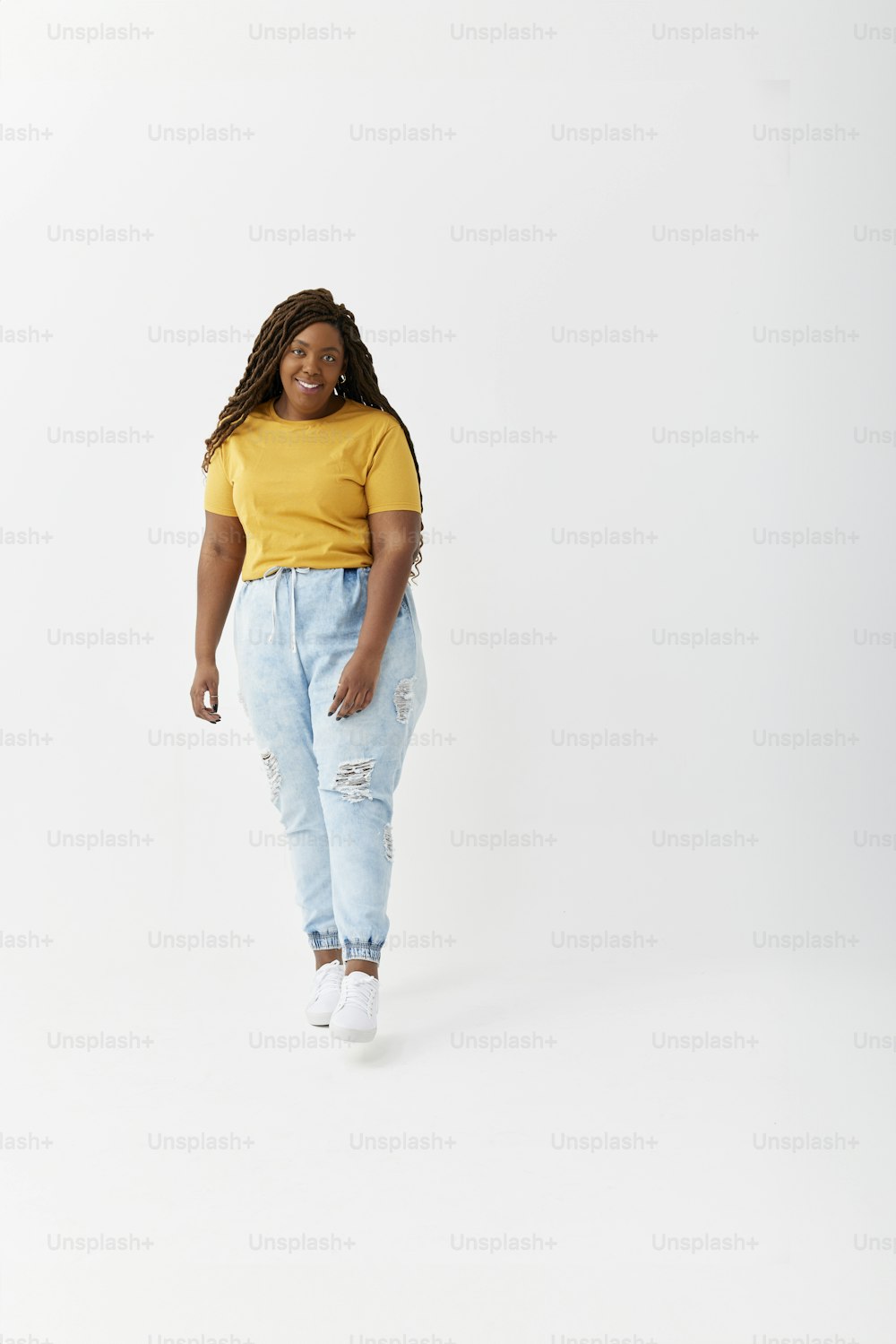 a woman in a yellow shirt and blue jeans