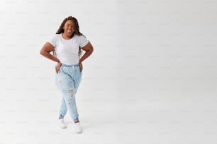 Eine Frau in weißem Hemd und Jeans posiert für ein Foto