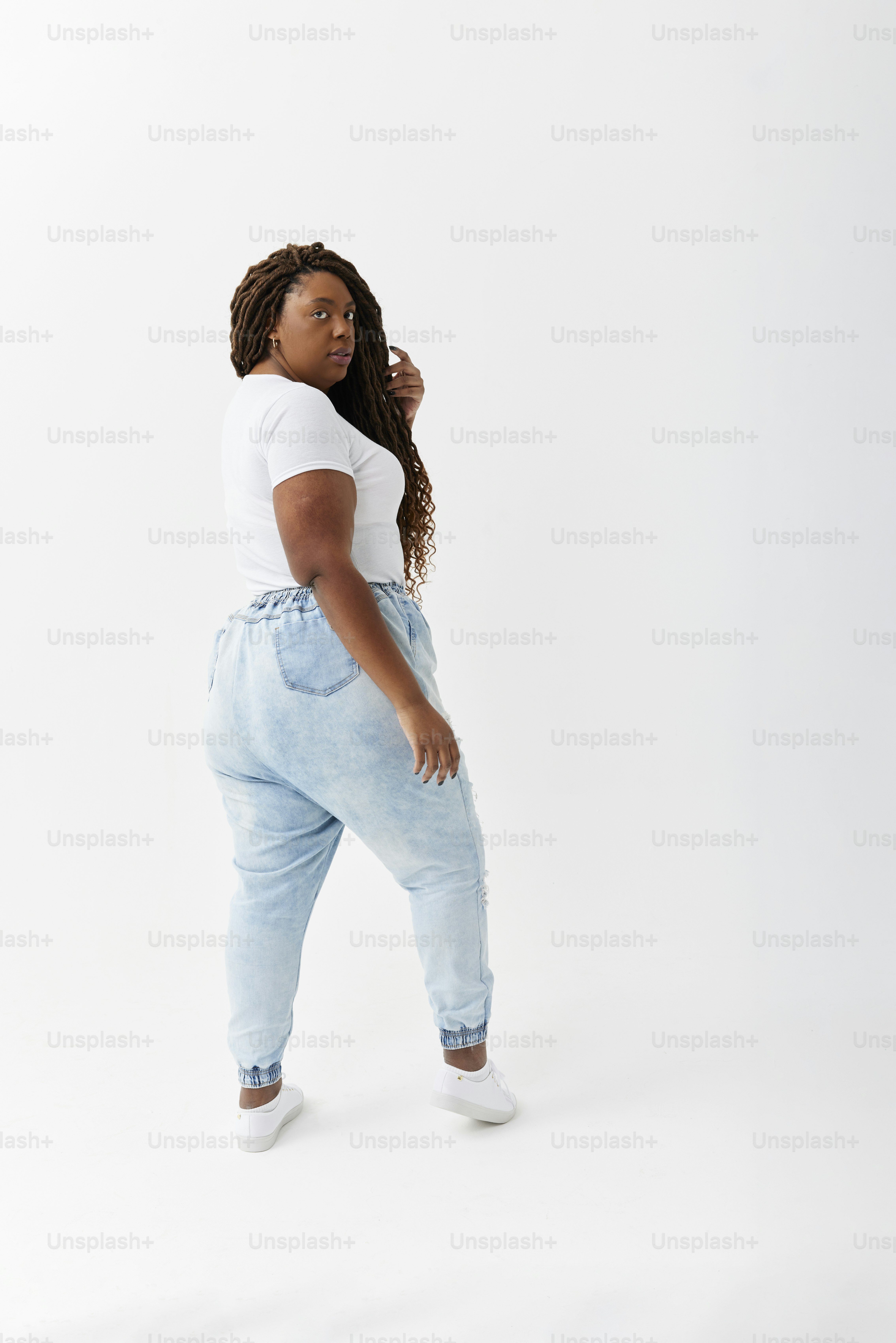 A woman in a white t - shirt and blue jeans photo – Plus size Image on ...