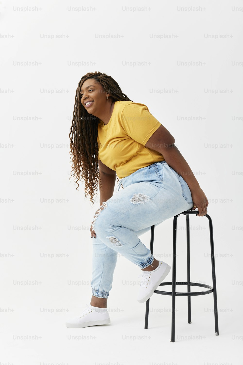 a woman sitting on top of a stool