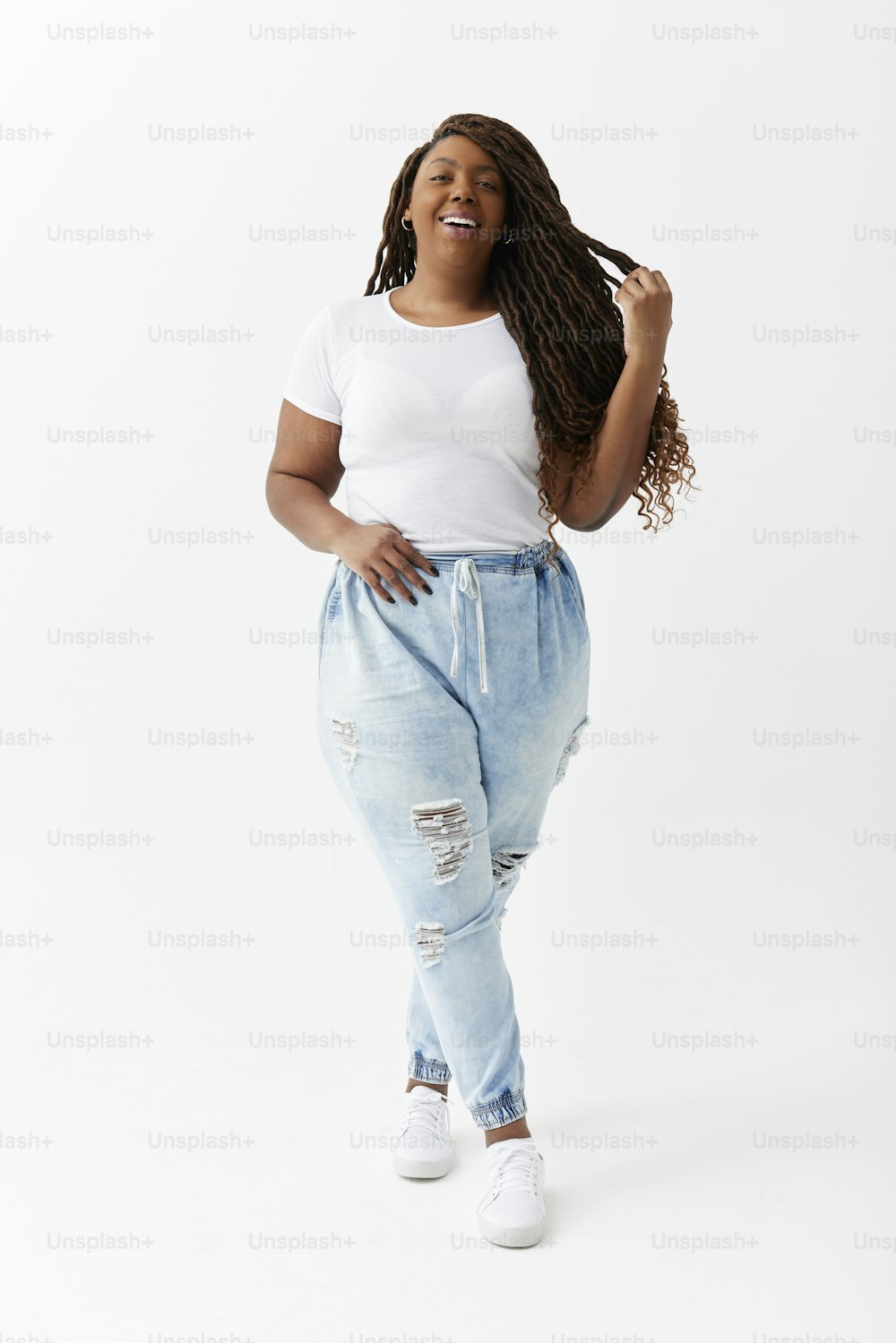 a woman in a white t - shirt and ripped jeans