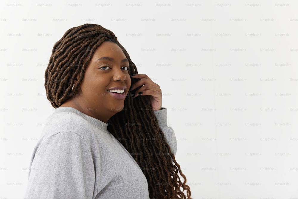 a woman with dreadlocks talking on a cell phone