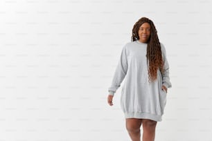 Eine Frau in einem grauen Pulloverkleid posiert für ein Foto