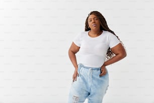 a woman in a white t - shirt is standing with her hands on her hips