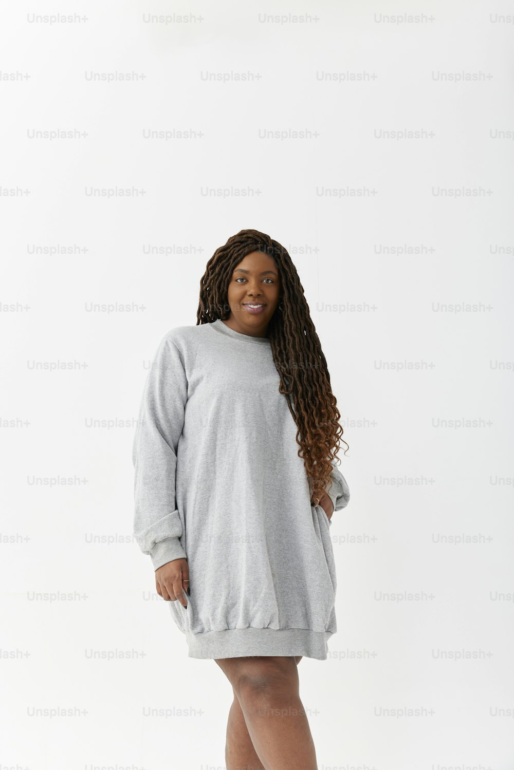 Una mujer con un vestido de suéter gris posando para una foto