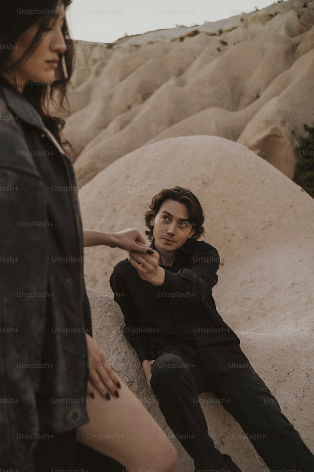 Ein Mann, der neben einer Frau auf einem Felsen sitzt