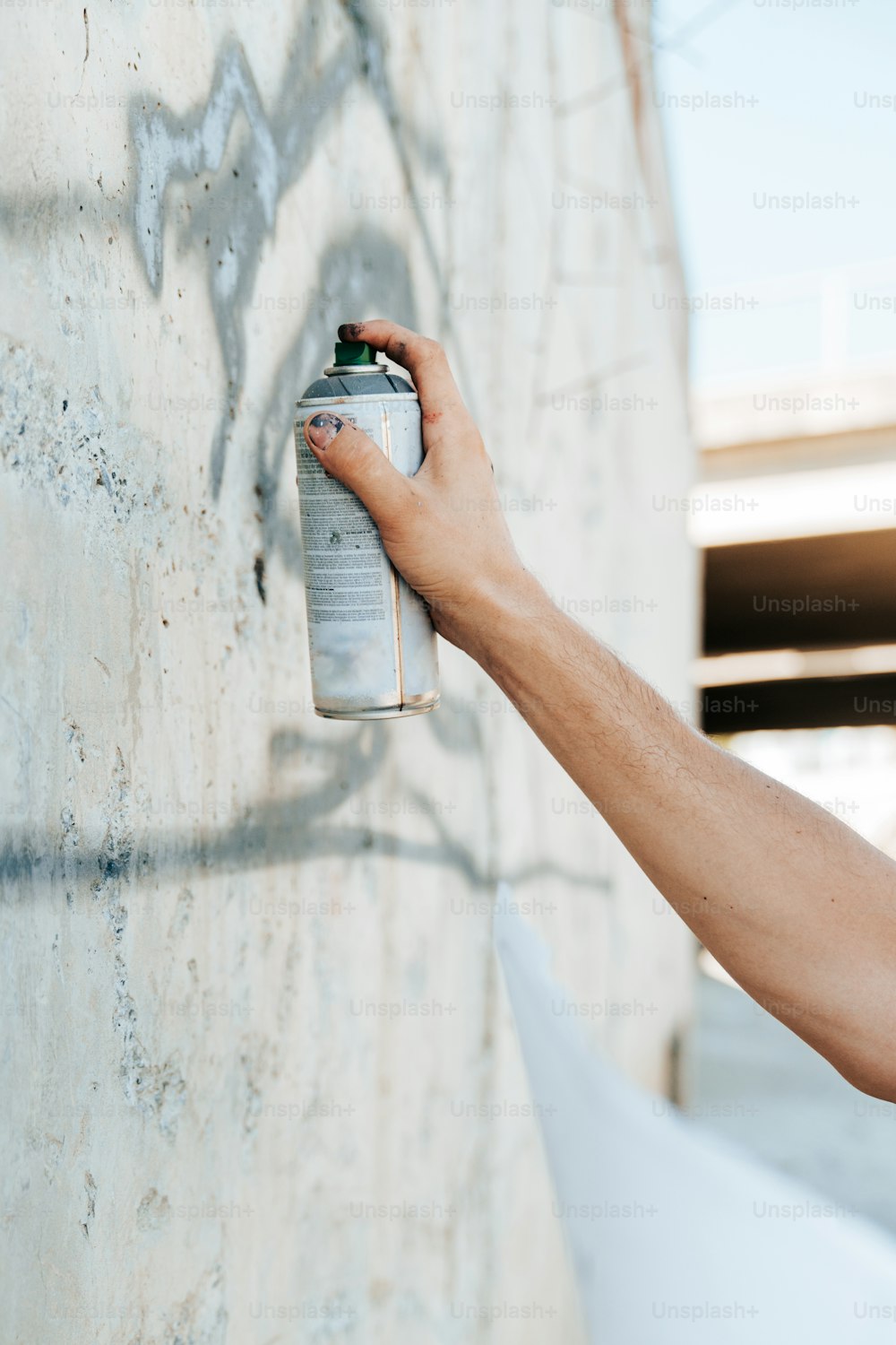 a person spray painting a wall with graffiti