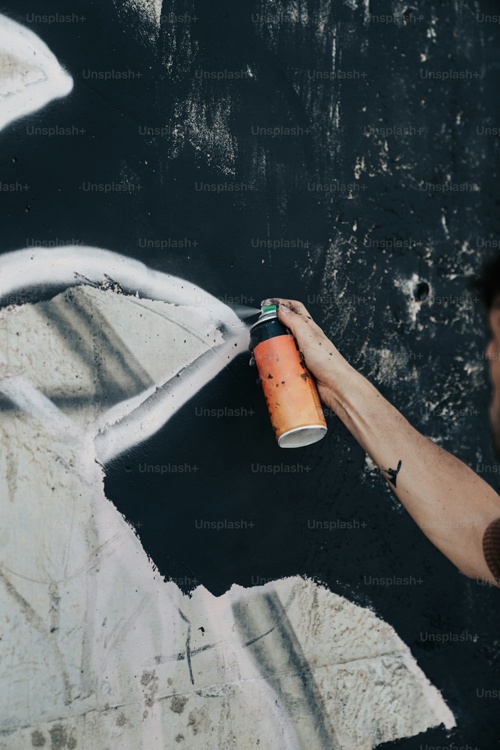 한 남자가 하얀 페인트로 벽을 칠하고 있다