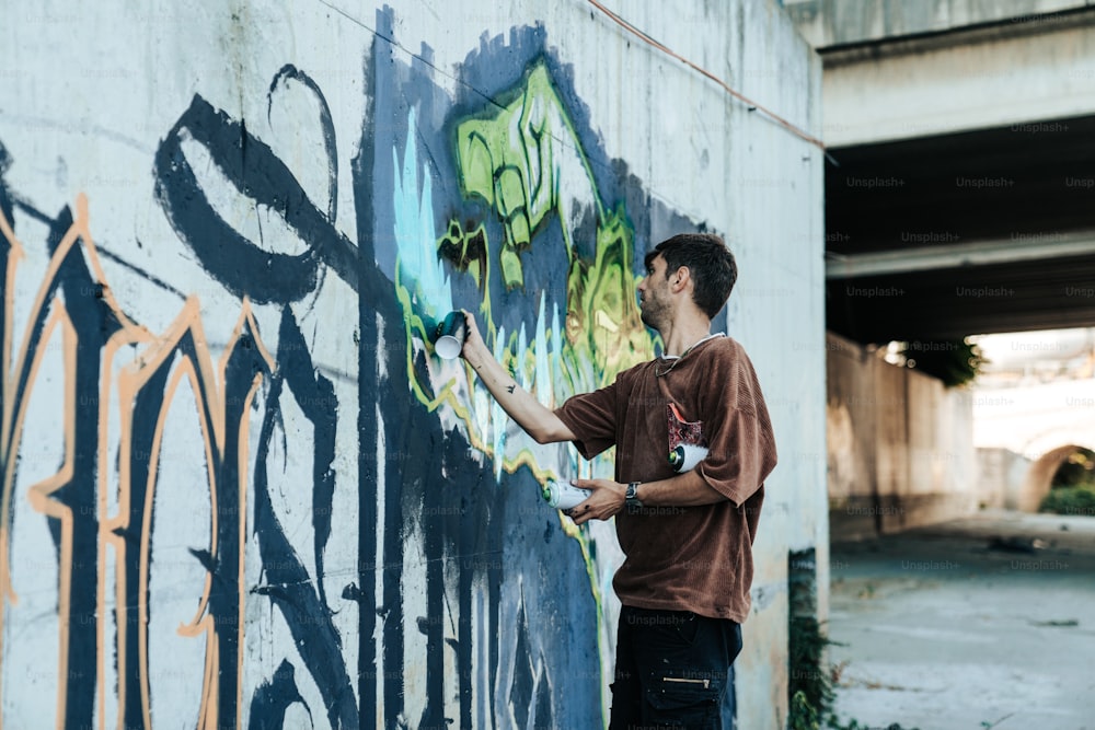 a man is painting graffiti on a wall