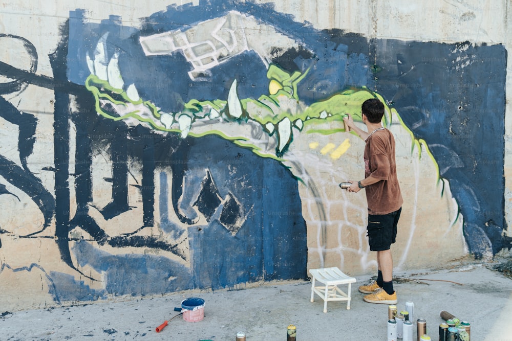 a man painting a mural on the side of a building