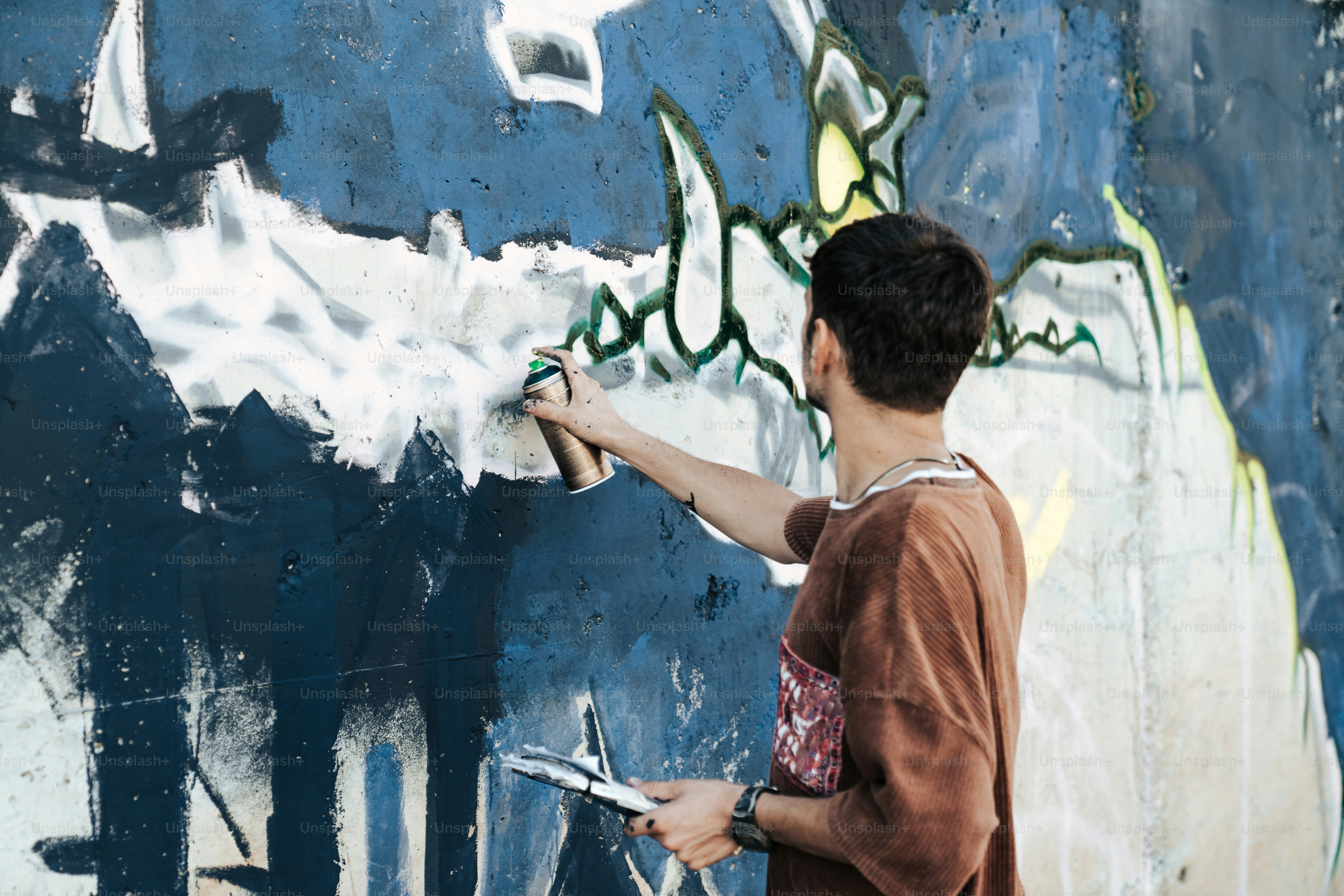 A man is painting a wall with graffiti photo – Graffiti Image on Unsplash