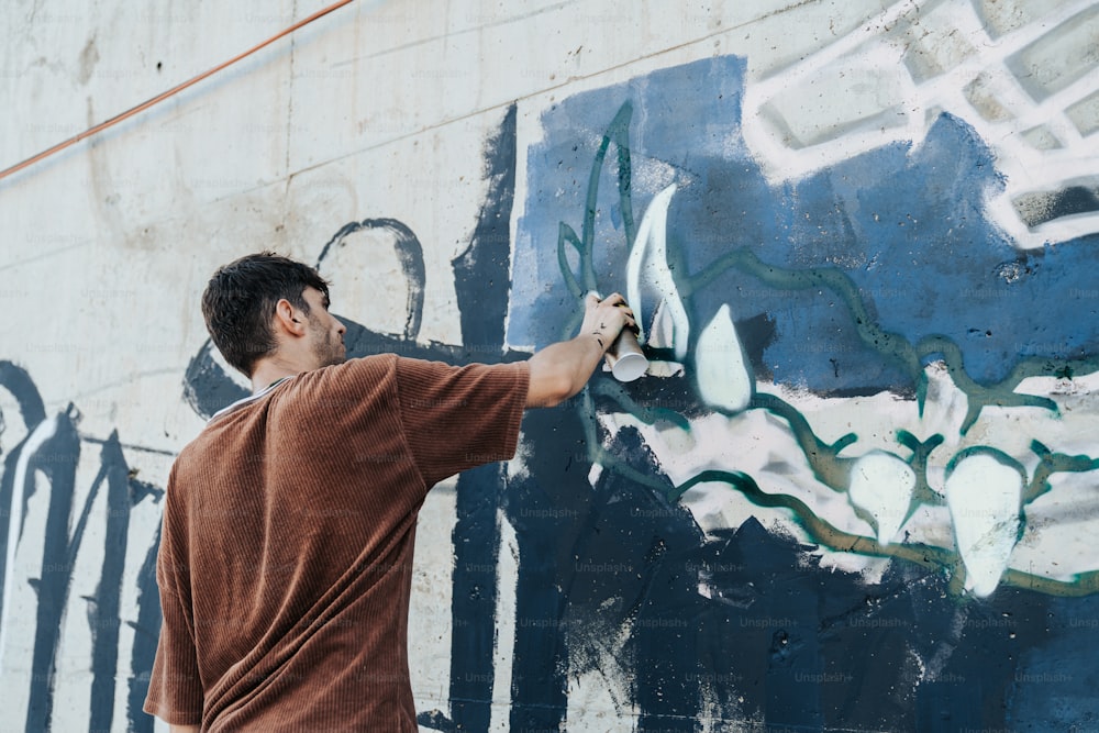 a man painting a wall with blue and white paint