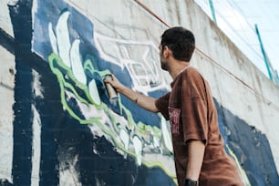 Un uomo che dipinge un muro con graffiti su di esso