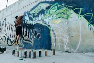a man painting a wall with spray paint