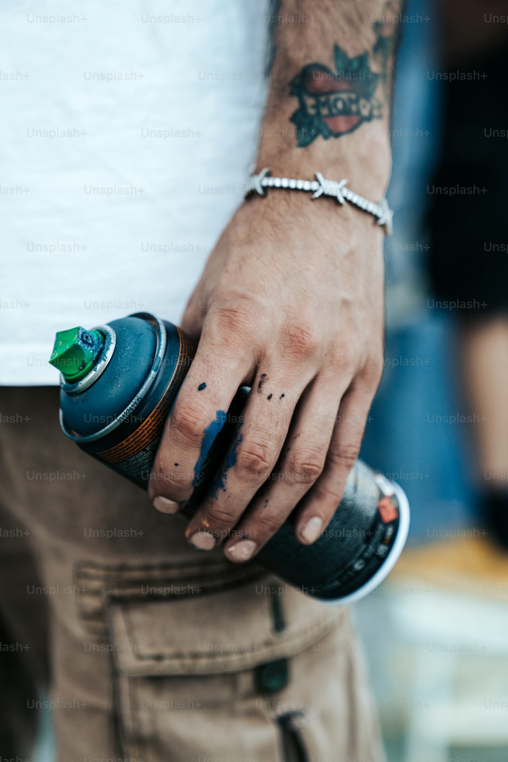a man with a tattoo on his arm holding a bottle