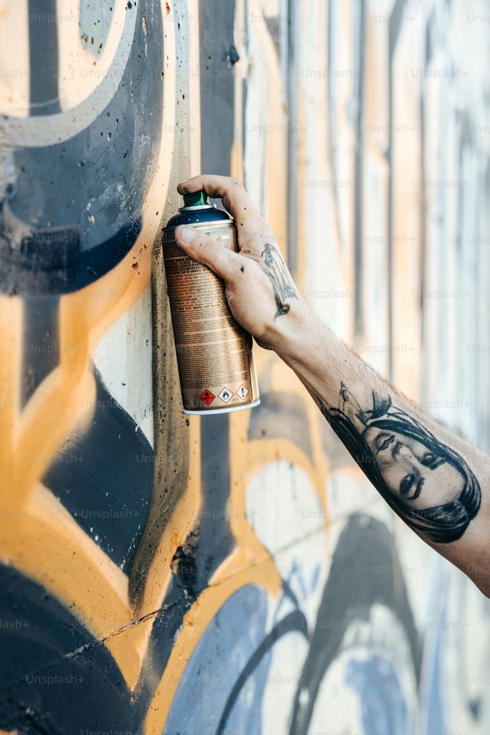 a man is spray painting a wall with graffiti