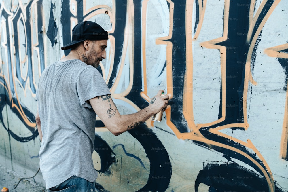 a man painting graffiti on the side of a building