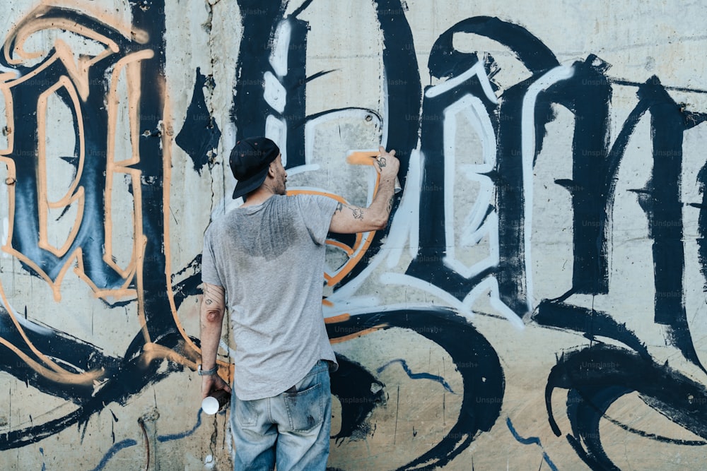 a man is painting a wall with graffiti