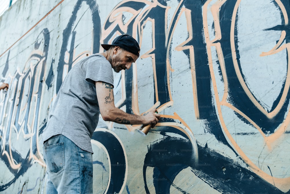 a man is painting a wall with graffiti