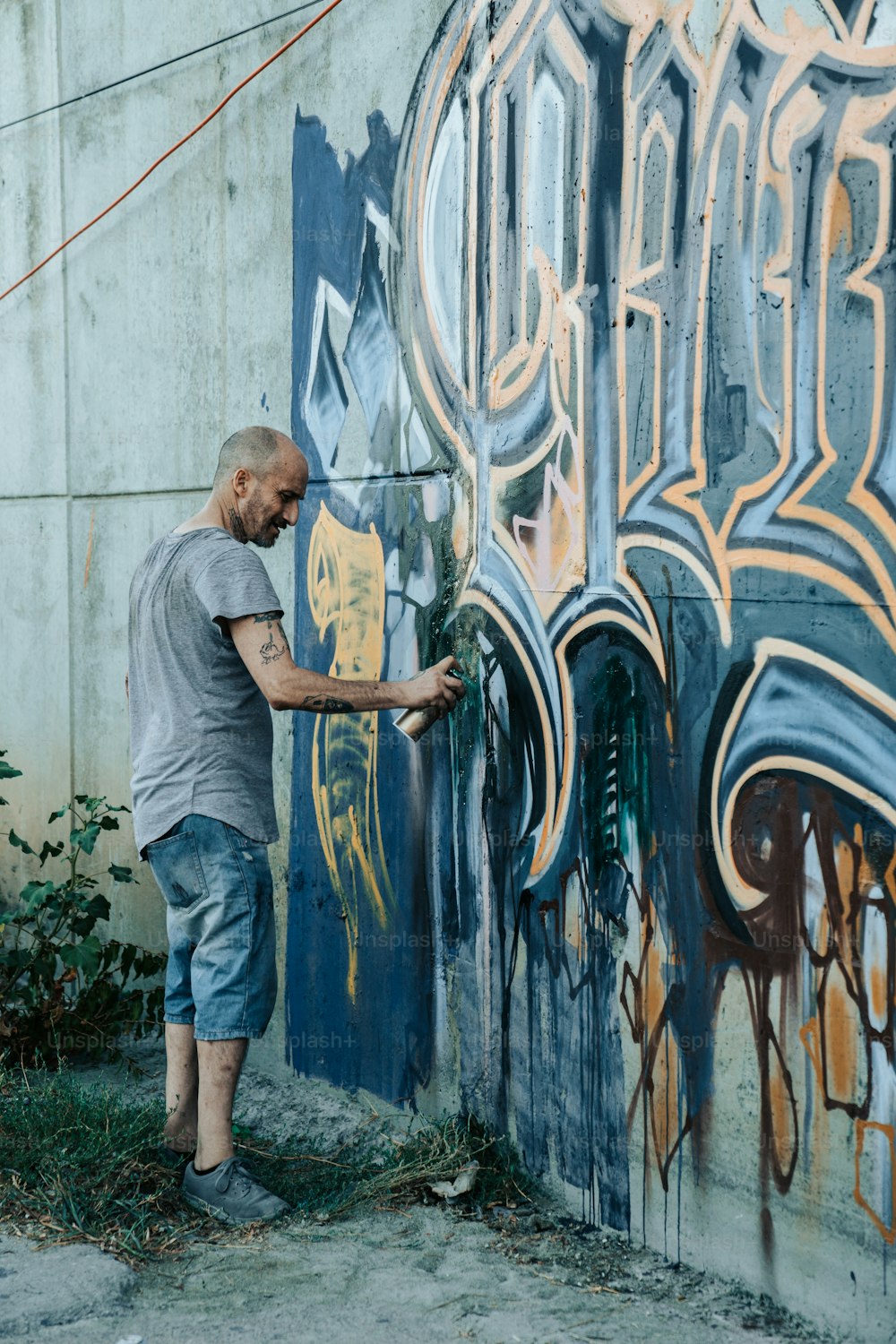 Un hombre pintando una pared con graffiti