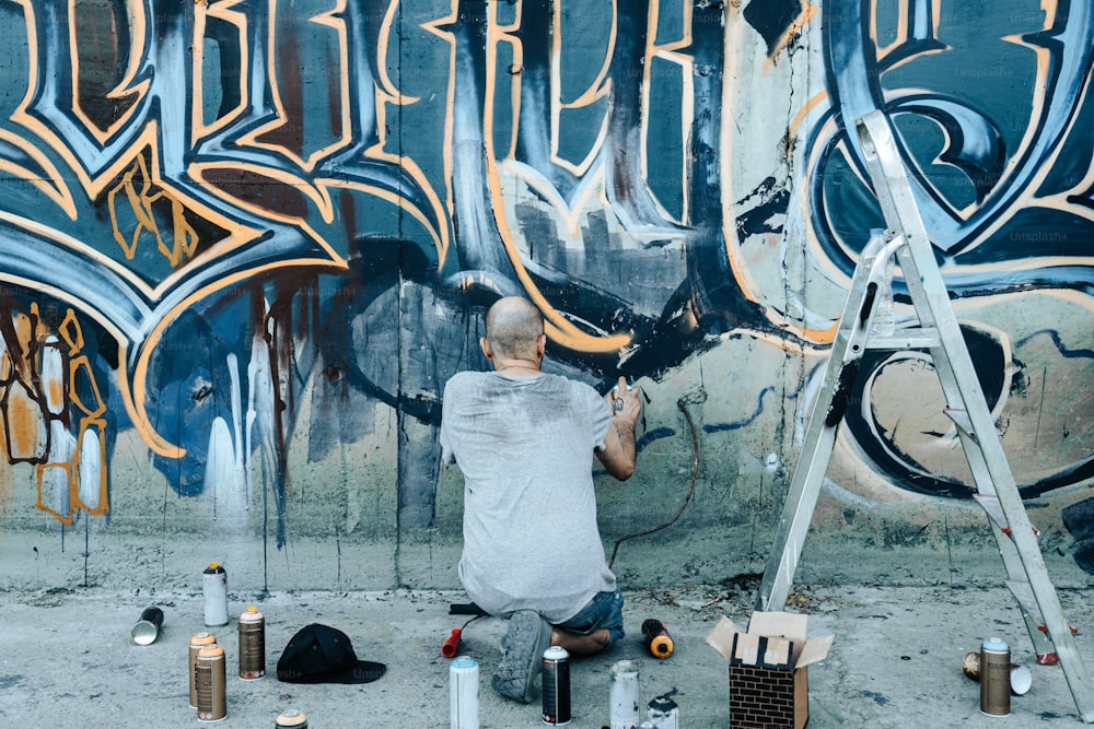 Ein Mann, der Graffiti an eine Wand malt