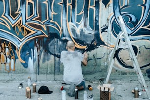 a man painting graffiti on a wall