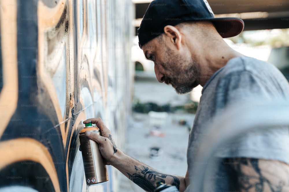 Un uomo sta dipingendo un muro con una pistola a spruzzo