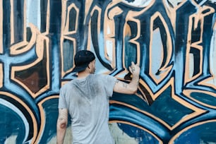 Un homme peint des graffitis sur un mur