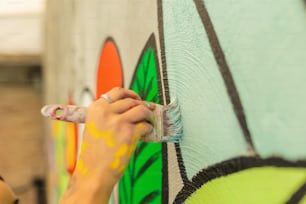 a woman painting a wall with a brush