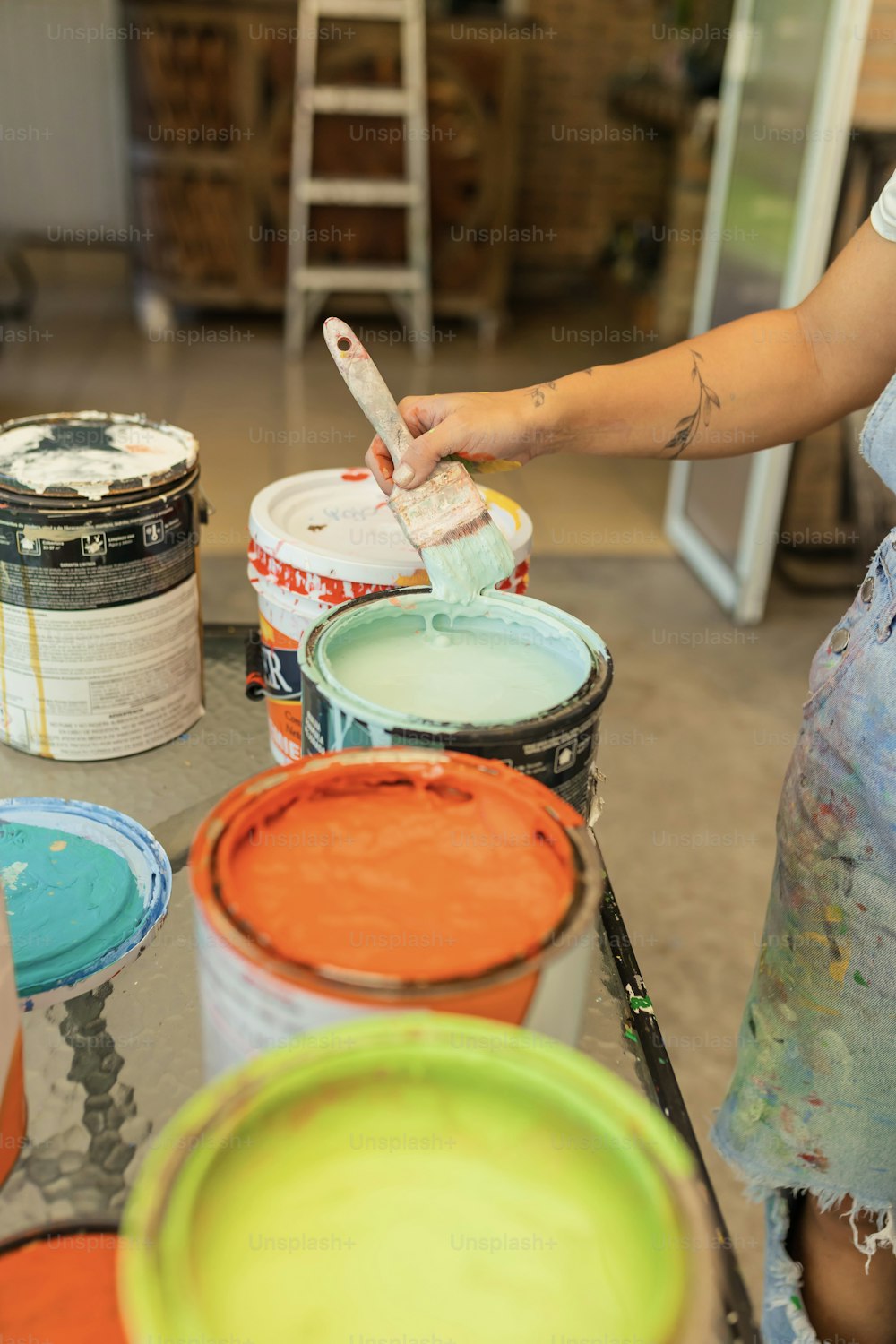 a woman is using a paintbrush to paint buckets