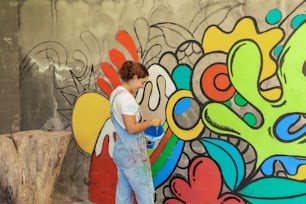 uma mulher está pintando um mural em uma parede