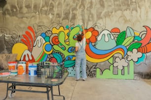 Una donna che dipinge un murale sul lato di un edificio