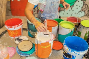 Una donna sta dipingendo un secchio di vernice su un tavolo