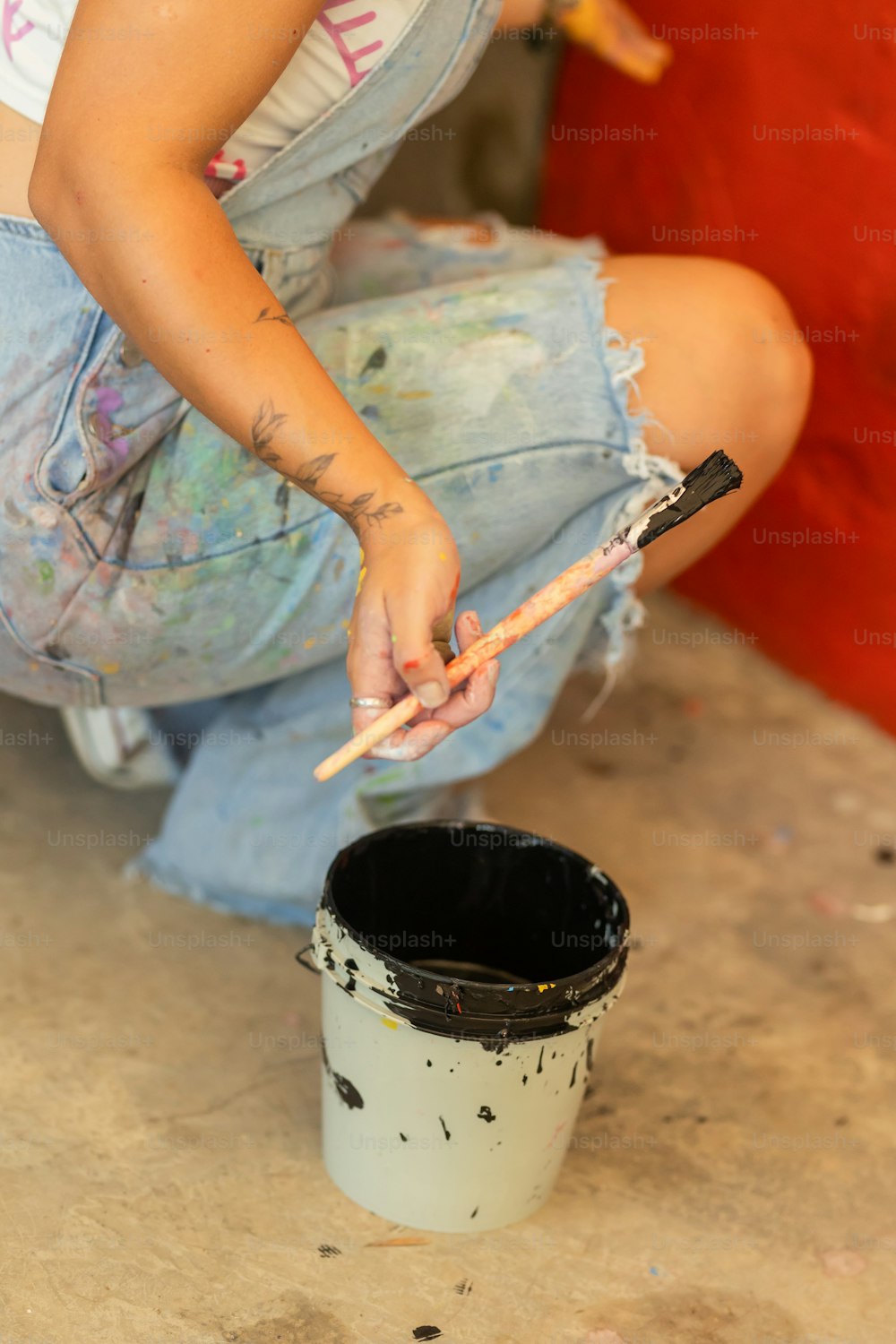 a woman is painting a bucket with a brush