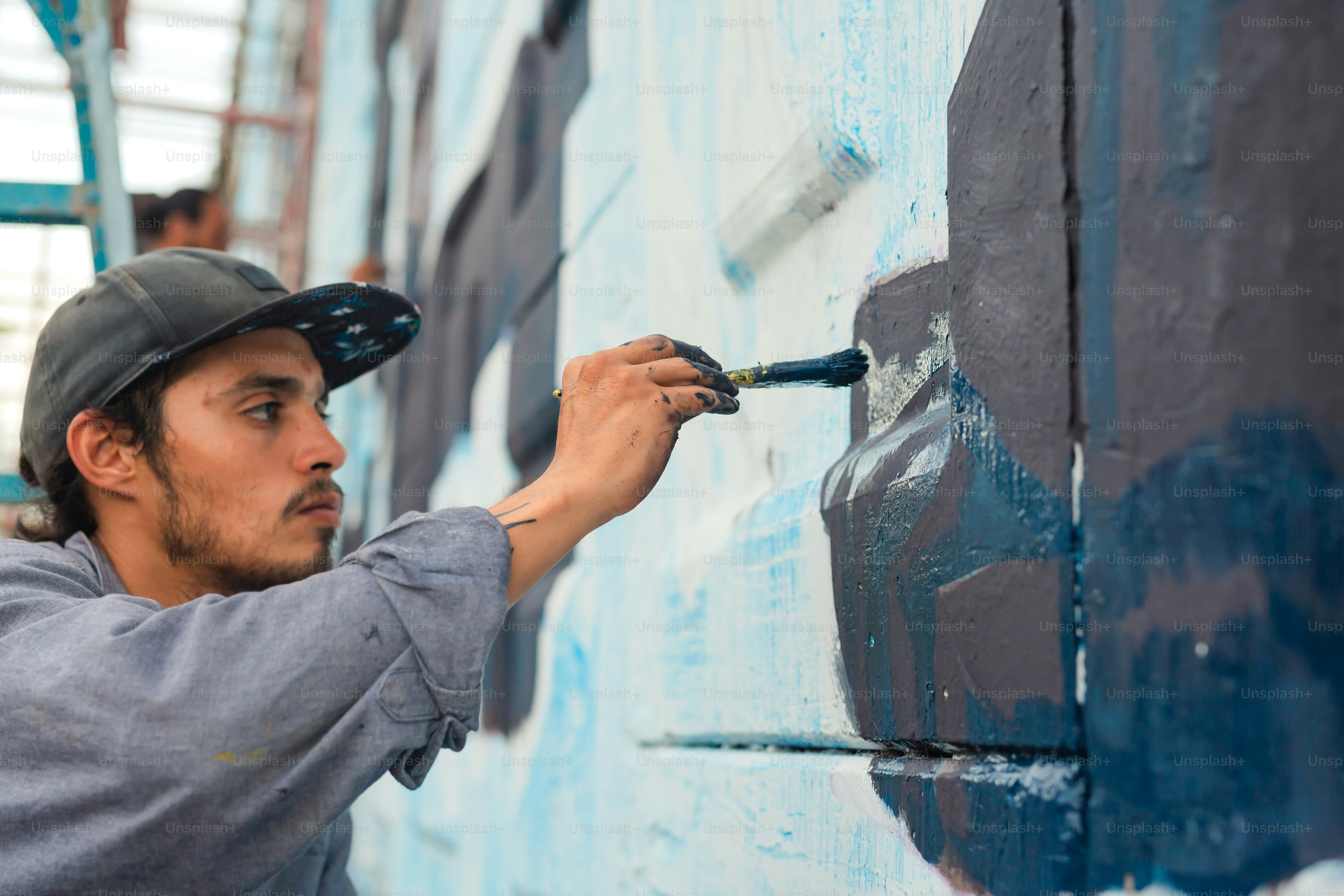 a man is painting a wall with blue paint