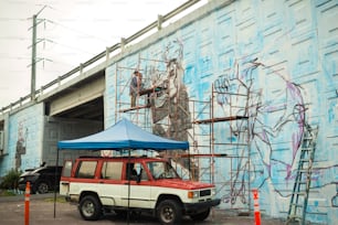 um caminhão vermelho e branco estacionado em frente a um muro azul