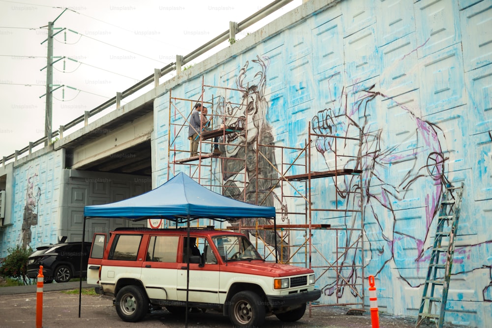 a red and white truck parked in front of a blue wall