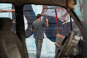 a man painting a mural on the side of a building