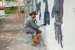 a man is painting a wall with blue paint