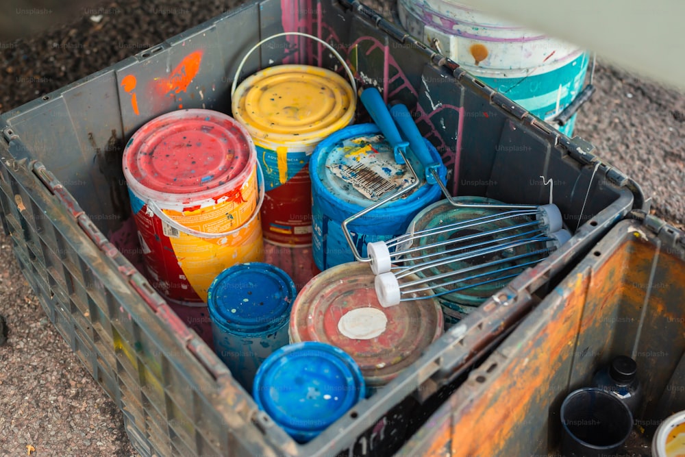 a container filled with paint and a whisk in it