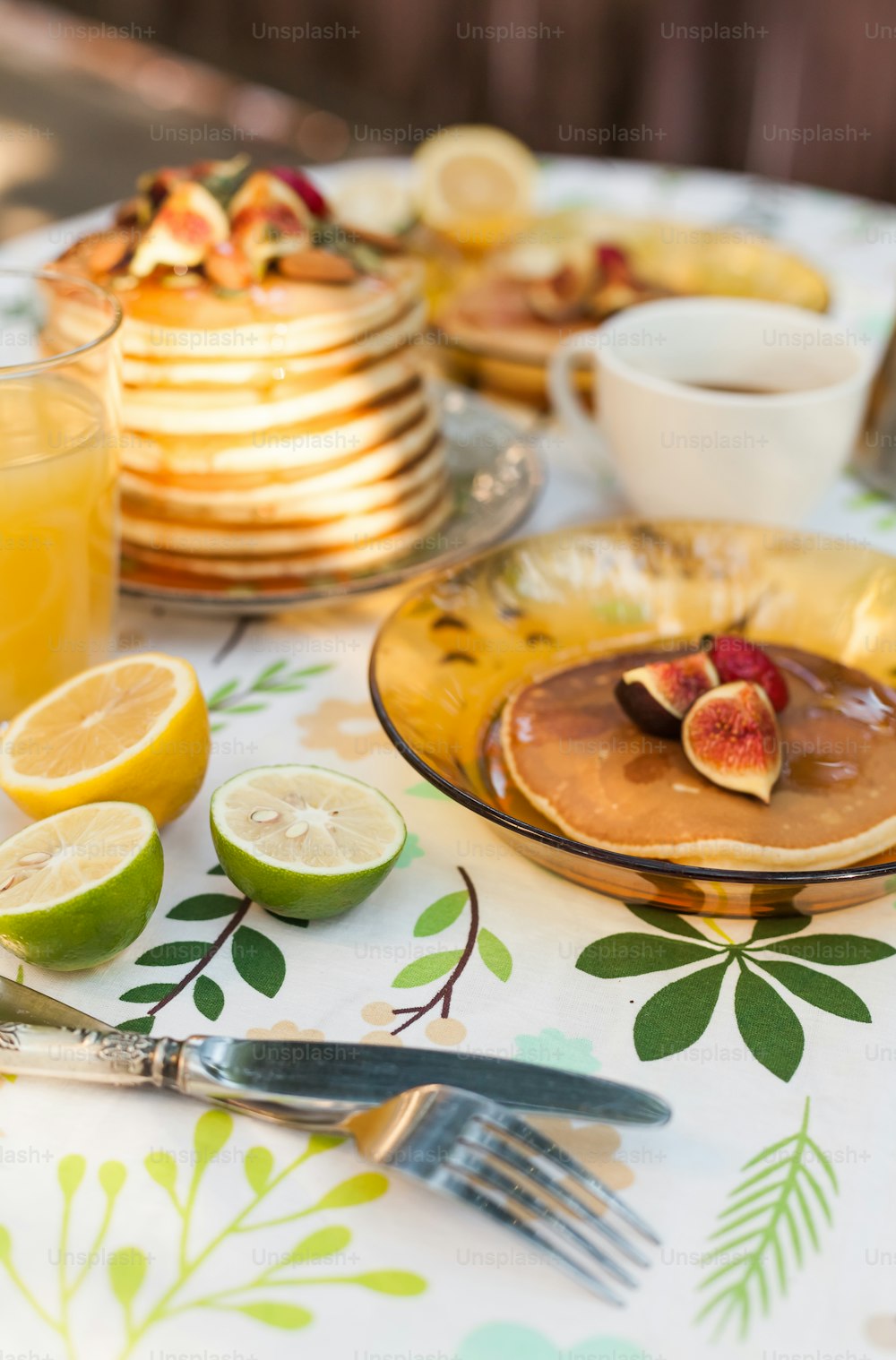 a table topped with plates of pancakes and fruit