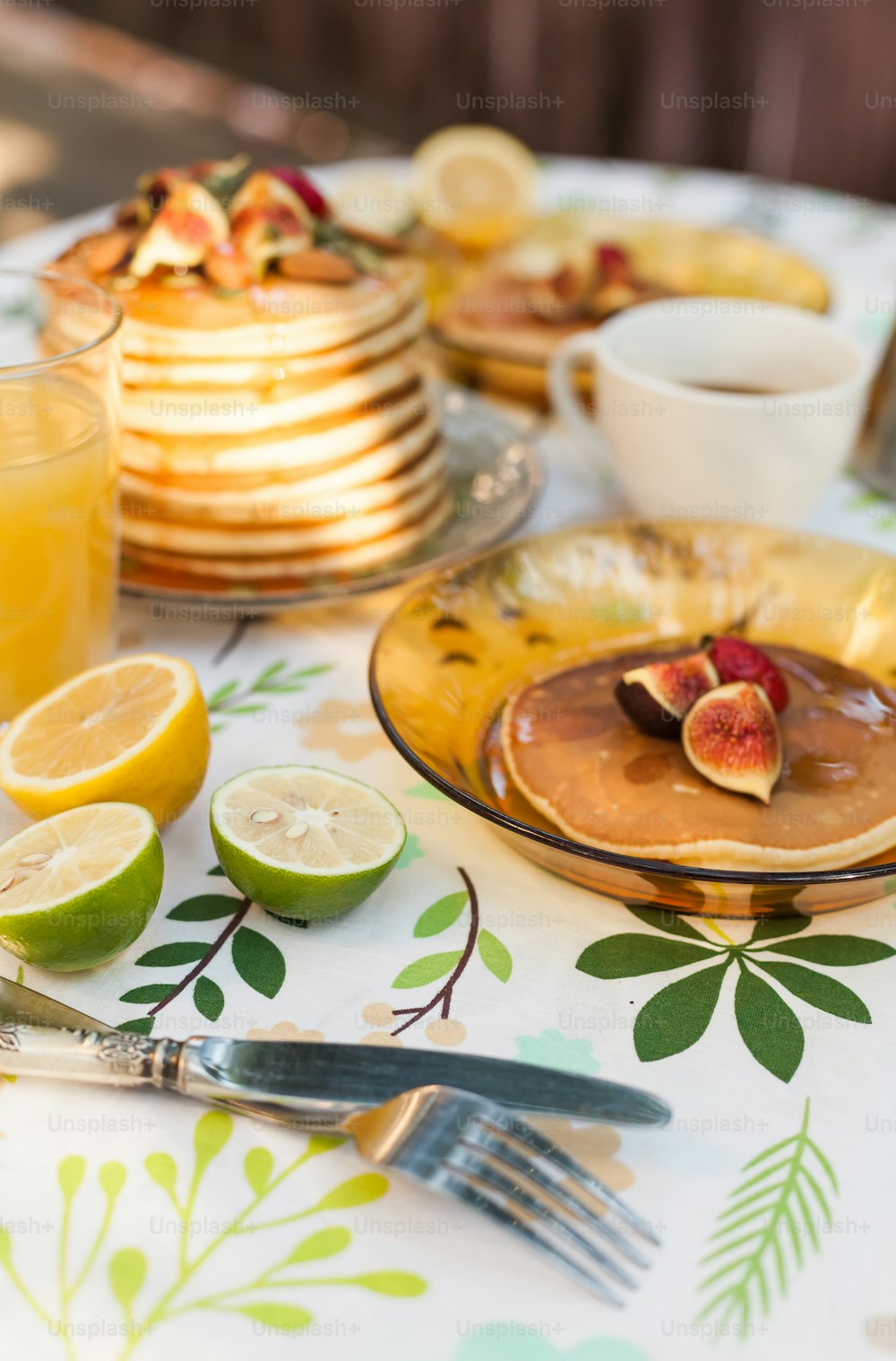 a table topped with plates of pancakes and fruit