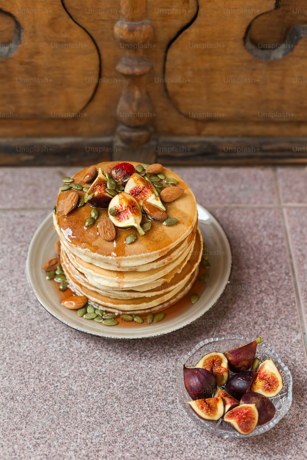 a stack of pancakes topped with fruit and nuts