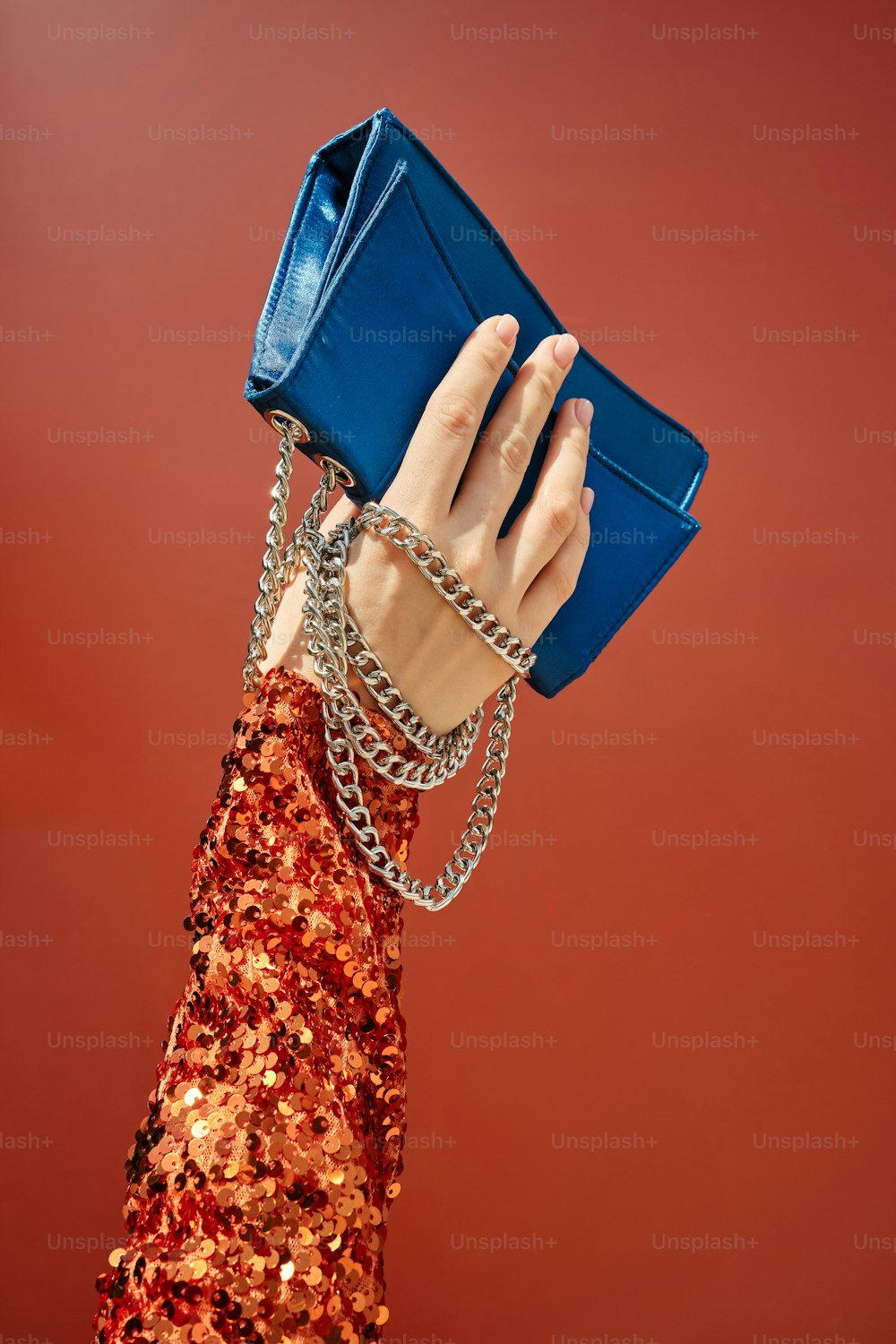 a woman holding a blue purse over her head